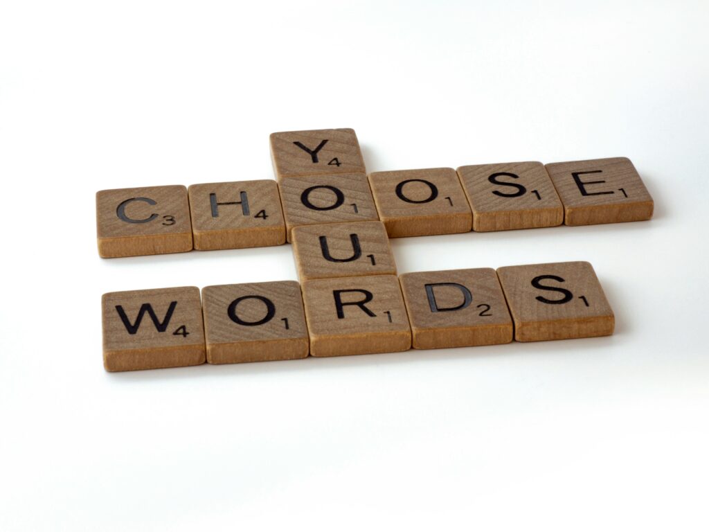 Wooden scramble pieces with the text "Choose your Words" - representing mindful communication and Clean Language.